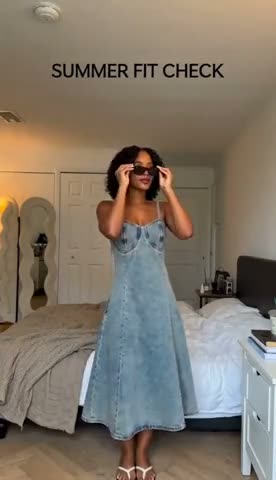 A light-wash denim midi dress tried on in a bedroom, finished with sunglasses and a white shoulder bag.
