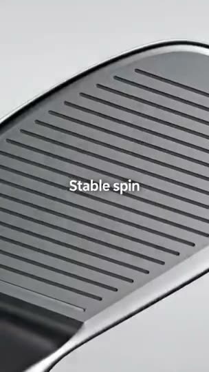 A macro pass across the milled grooves of a wedge face, then a ball sitting on the green.